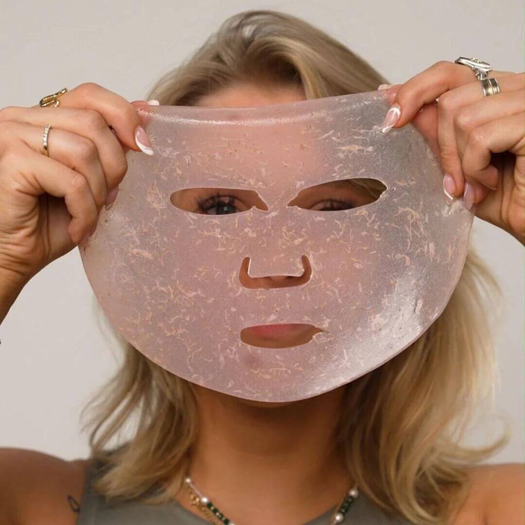 Dame, der holder ansigtsmaske lavet med Comforth Mask machine op foran hendes ansigt